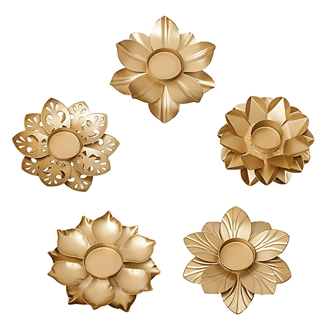 Five gold-toned flower-shaped decorative accessories arranged on a plain white background, with different petal and cutout designs.